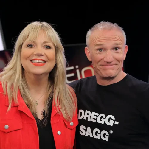 Komikerin Mirja Regensburg im roten Blazer neben Michl Müller im „Dregg-Sagg“-Shirt in der BR-Show Drei.Zwo.Eins.