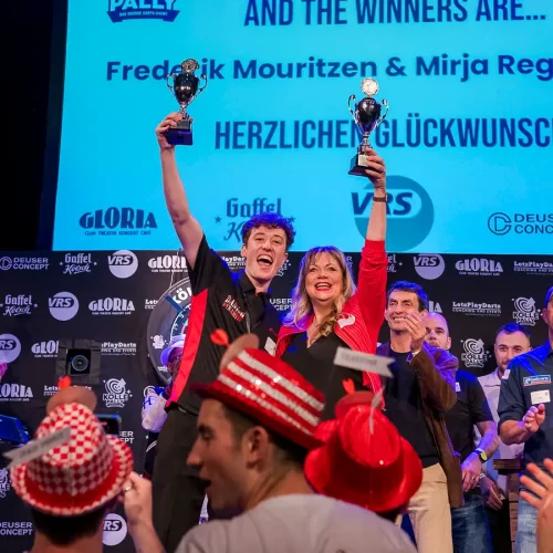 Komikerin Mirja Regensburg reckt mit Frederik Mouritzen den Siegerpokal des „Kölle Pally“ auf der Bühne des Gloria Theaters in Köln.