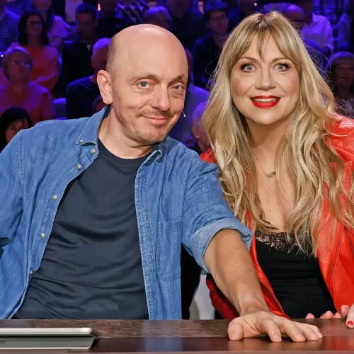 Komikerin Mirja Regensburg lächelt mit Bernhard Hoëcker am Ratepult der ARD-Show „Wer weiß denn sowas?“.