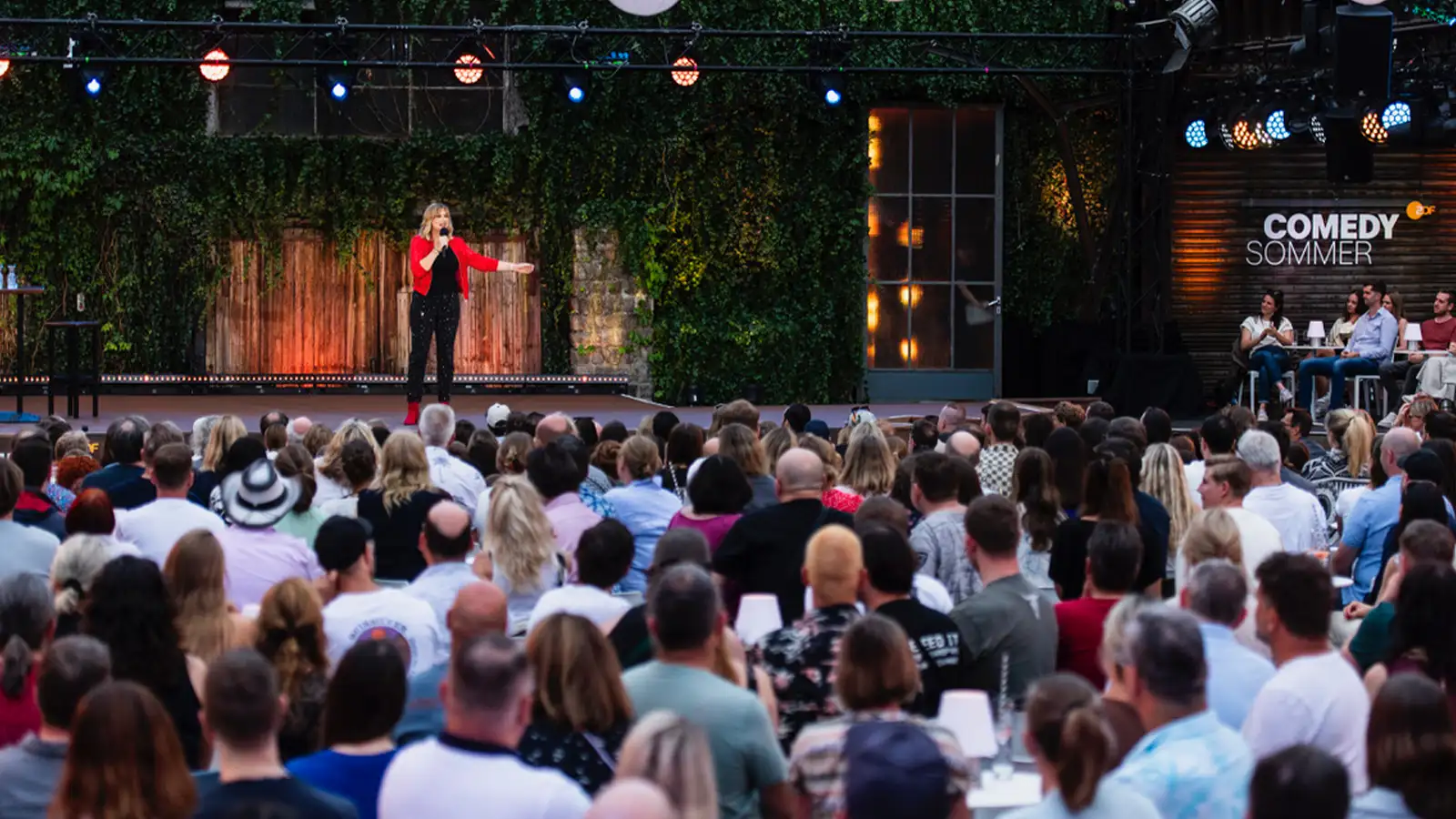 Open-Air-Bühne des ZDF Comedy Sommer in Köln mit Mirja beim Stand-up und großem Publikum unter Lampions